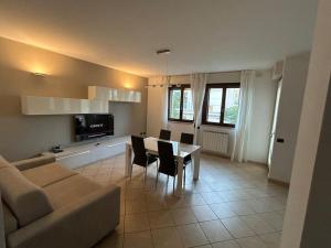 a living room with a couch and a table and chairs at La casa smart zona stadio in Terni
