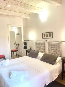 a bedroom with a large white bed with a red chair at B&B La Casa Di Tufo in Orvieto
