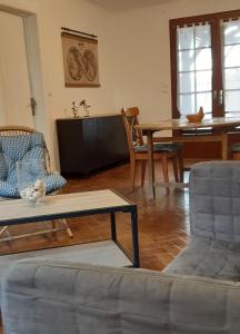 a living room with a couch and a table at Les Bruyères - Maison in Léon