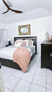 une chambre avec un lit et un ventilateur de plafond dans l'établissement Tropical Luxe Modern Townhouse, à Montego Bay