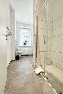 ein Badezimmer mit Dusche und Waschbecken in der Unterkunft Modernes Apartment mit Queensize-Bett, NETFLIX, Küche, Erdgeschoss, Nähe AMEOS Klinik in Aschersleben