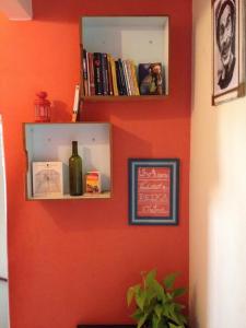 a red wall with a shelf with a bottle of wine at Ramon Hostel Bar in Recife