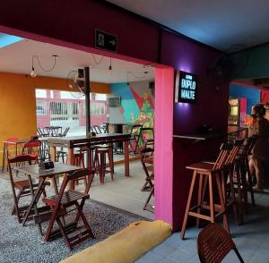 a restaurant with tables and chairs and a pink wall at Ramon Hostel Bar in Recife
