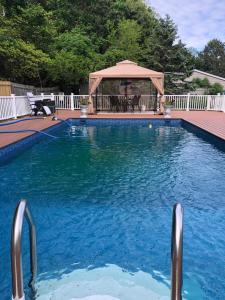 a large blue swimming pool with a gazebo at A sweet suite in Westhampton Beach