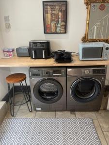 a kitchen with a washing machine and a microwave at The Airpad in Kegworth