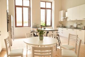 a kitchen with a white table and chairs at HUB Portanova in Trani