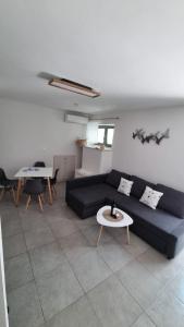 a living room with a blue couch and a table at G-House Skiathos in Skiathos