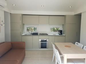 a kitchen and dining room with a table and a couch at CAMPING RÊVE DES ILES in Argelès-sur-Mer