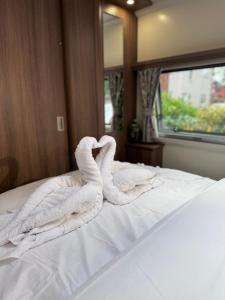 a white towel sitting on top of a bed at Tayys Inn Luxury Camp in Birmingham