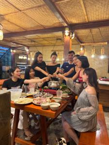 a group of people sitting around a table with food at Mường Lống Ecogarden in Kỳ Sơn