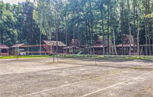una pista de tenis con una red frente a las casas en Holiday Home Lukecin Ulsloneczna Ii, en Łukęcin 5 fotos más
