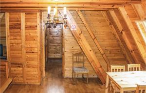 una escalera en una cabaña de madera con mesa y sillas en Holiday Home Lukecin Ulsloneczna Ii, en Łukęcin