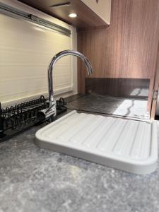 a kitchen sink with a faucet on a counter at Tayys Inn Luxury Camp in Birmingham