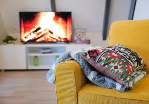 a blanket on a chair with a fire in the background at Vikendica DORMINO in Bihać