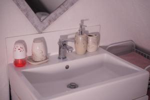 a bathroom sink with two faucets and three candles at Vikendica DORMINO in Bihać +12 photos