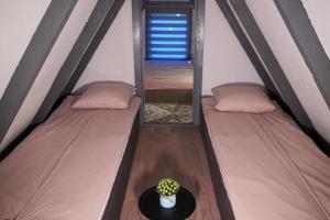 a room with two beds with a table and a mirror at Vikendica DORMINO in Bihać