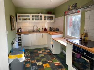 a kitchen with white cabinets and a tile floor at La Bruyere du Coq Stables in Sart-Dames-Avelines