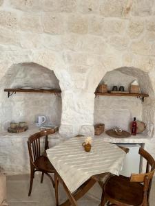 a table and chairs in a room with a stone wall at Agli Antichi Trulli in Alberobello