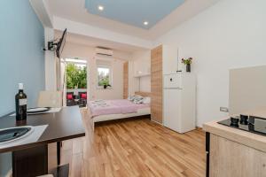 eine Küche und ein Wohnzimmer mit einer Spüle und einem Kühlschrank in der Unterkunft Apartmani DALI in Novalja