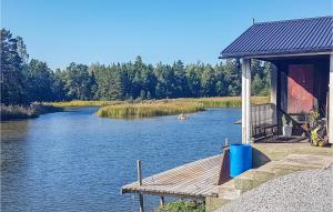 a river with a wooden dock and a building at Nice Home In Ljusne With Wifi in Ljusne +17 photos