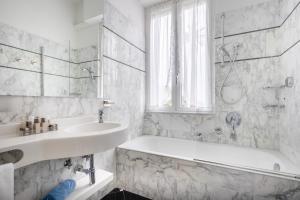 a white bathroom with a tub and a sink at Hotel Metropole in Santa Margherita Ligure