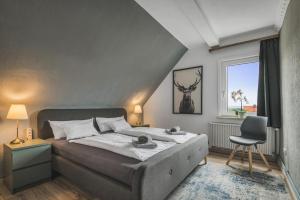 a bedroom with a bed and a chair and a window at Hirsch-Apartment-5 Eulennest in Bad Harzburg