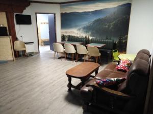 a living room with a couch and a table at Hotel du Lac - Au Bord du Lac in La Tour-dʼAuvergne