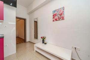 ein weißer Raum mit einer Bank und einem Gemälde an der Wand in der Unterkunft Apartmani DALI in Novalja + 72 Fotos