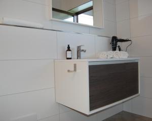 eine Küchentheke mit einem Waschbecken und einem Spiegel in der Unterkunft Ferienwohnung mit Balkon I Bergblick I Parkplatz Apartment ONE in Bad Hindelang + 6 Fotos