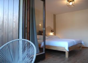 ein Schlafzimmer mit einem Bett, einem Stuhl und einem Spiegel in der Unterkunft Ferienwohnung mit Balkon I Bergblick I Parkplatz Apartment ONE in Bad Hindelang