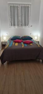 a bedroom with a bed with pillows and a window at corse location in Linguizzetta