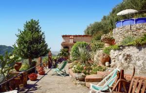 a garden with lawn chairs and flowers in front of a house at Casa La Borra in Camaiore +23 photos
