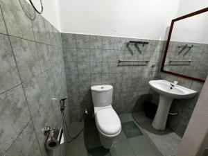 a bathroom with a toilet and a sink at Full Moon Resort in Unawatuna