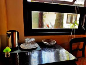 a table with a coffee pot and glasses on it at Full Moon Resort in Unawatuna