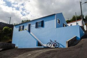a bike parked in front of a blue building at Sunrise House in Companhia de Baixo