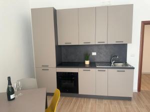 a kitchen with white cabinets and a table at 11cinque in Corato