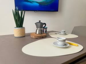 a table with a coffee pot and cups on it at 11cinque in Corato