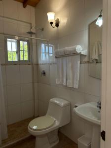a white bathroom with a toilet and a sink at Apartamento Playa Zaragoza by La casa Rosada in Guayacán