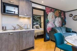 a kitchen with a sink and a living room at Best Western Les Bains Hotel et SPA in Perros-Guirec