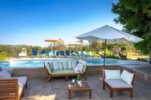 eine Terrasse mit Stühlen und Sonnenschirm und ein Pool in der Unterkunft Cozy and Chic Little House with Pool Ivinj-2 in Tisno
