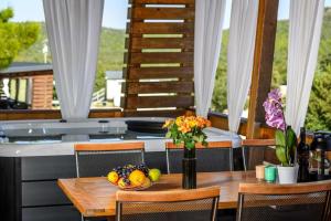 einen Tisch mit einer Schale Obst und einer Vase Blumen in der Unterkunft Cozy and Chic Little House with Pool Ivinj-2 in Tisno
