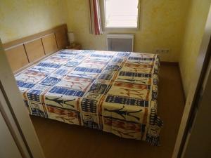 a bed with a quilt on it in a room at Appartement de 3 pièces au centre d'Isola 2000, parking, proche pistes - FR-1-292-210 in Isola