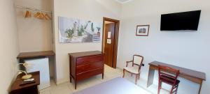 a room with a desk and a tv on a wall at Masseria San Nicola B&B in Torre Santa Susanna