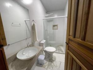 a white bathroom with a sink and a toilet at Recanto do Matuto in Amargosa