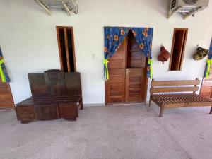 a room with a wooden door and a wooden bench at Recanto do Matuto in Amargosa