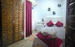 a bedroom with a bed with red pillows at Casa de la Felicidad cerca de la playa in Santa Pola