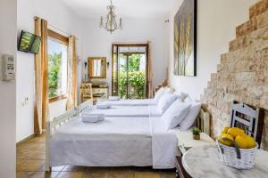 a bedroom with two beds and a stone wall at Yianna Sunny Studios in Skopelos Town