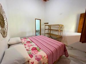a bedroom with a bed with a pink blanket at Recanto do Matuto in Amargosa