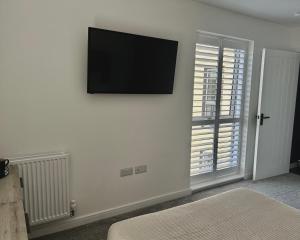 a living room with a flat screen tv on a wall at Millicent Room in Littlehampton