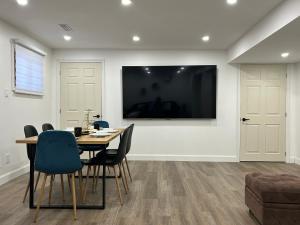 a dining room with a table and chairs and a flat screen tv at Bancroft VIBES l Sleep 7 l BBQ I FIRE PIT in Bancroft